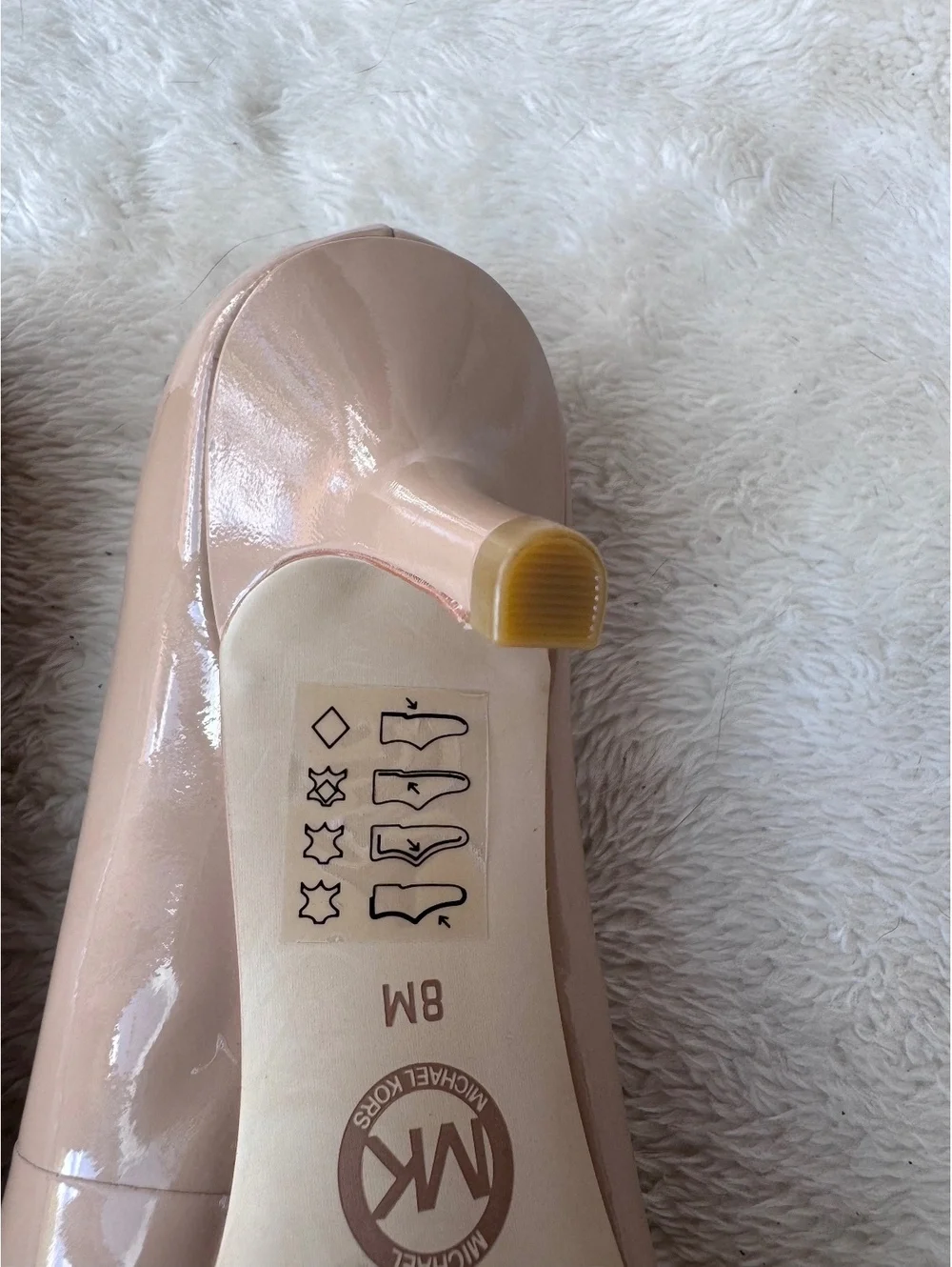 Michael Kors women’s patent leather peep-toe pumps in a classic nude/blush color